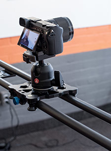 Close-up of a camera mounted on a tripod head, mounted to a Cameron slider