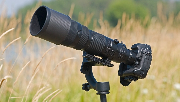 A DSLR with a telephoto lens attached, on a monopod with a gimbal head