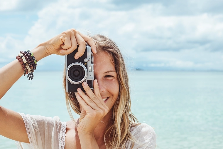 A photographer taking a photo at the beach while on vacation