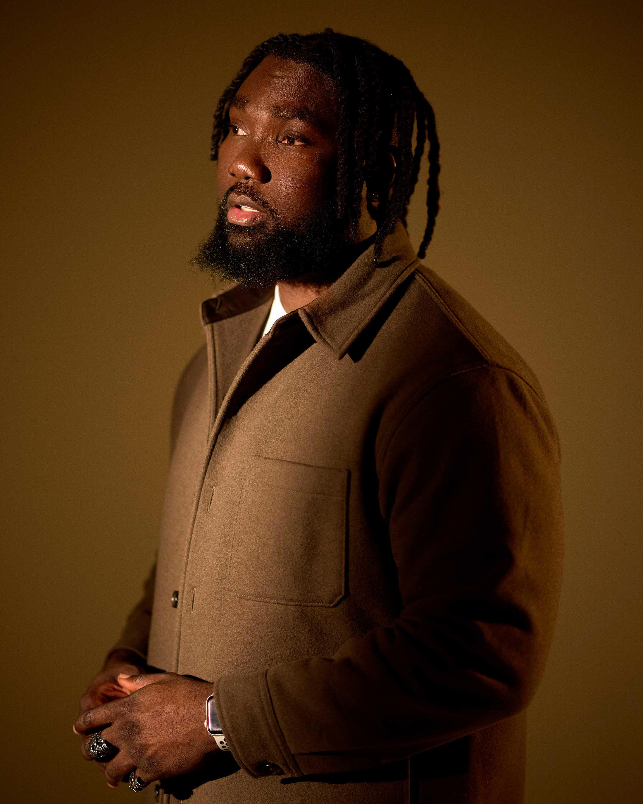 A young black man with short, braided hair and a beard.