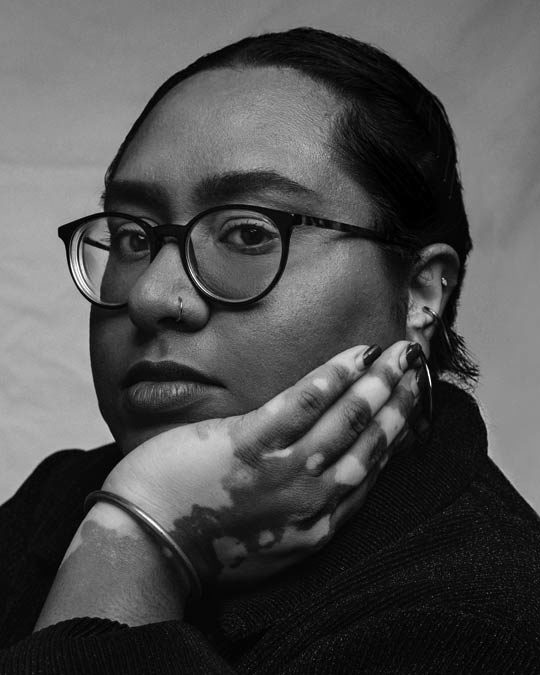 Closeup of a woman resting her face on her hand.