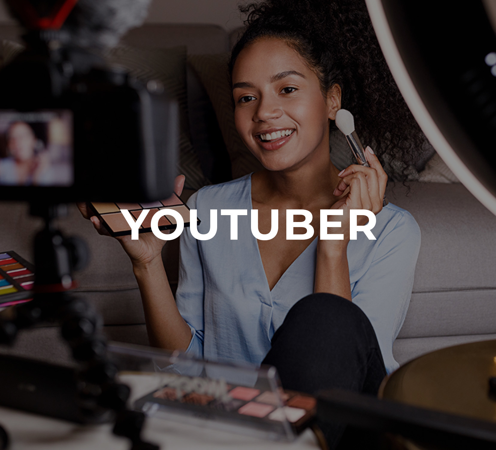 A young woman in front of a camera demonstrating how to put on make up