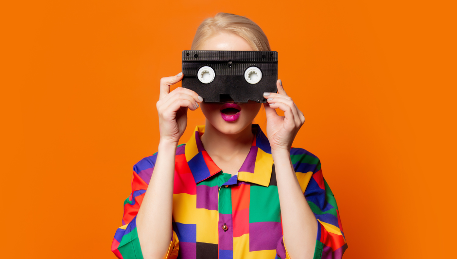 A woman holding a video tape in front of her face