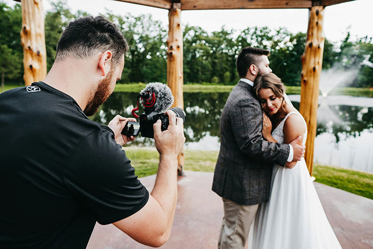 A young photographer taking a photo of a wedding couple dancing