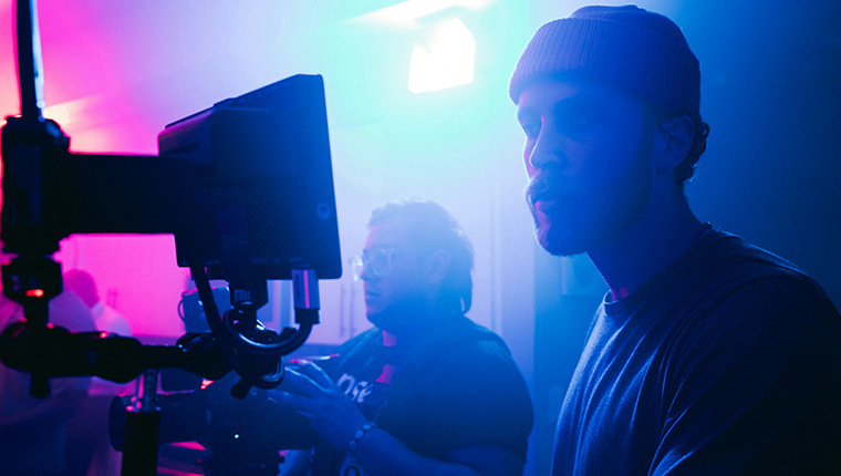 Videographers in a blue-lit studio