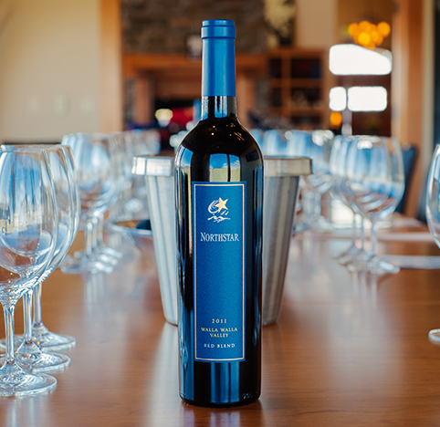 Bottle of Walla Walla Valley Red Blend on a table with glasses