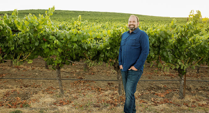 James Hall standing in front of a vineyard