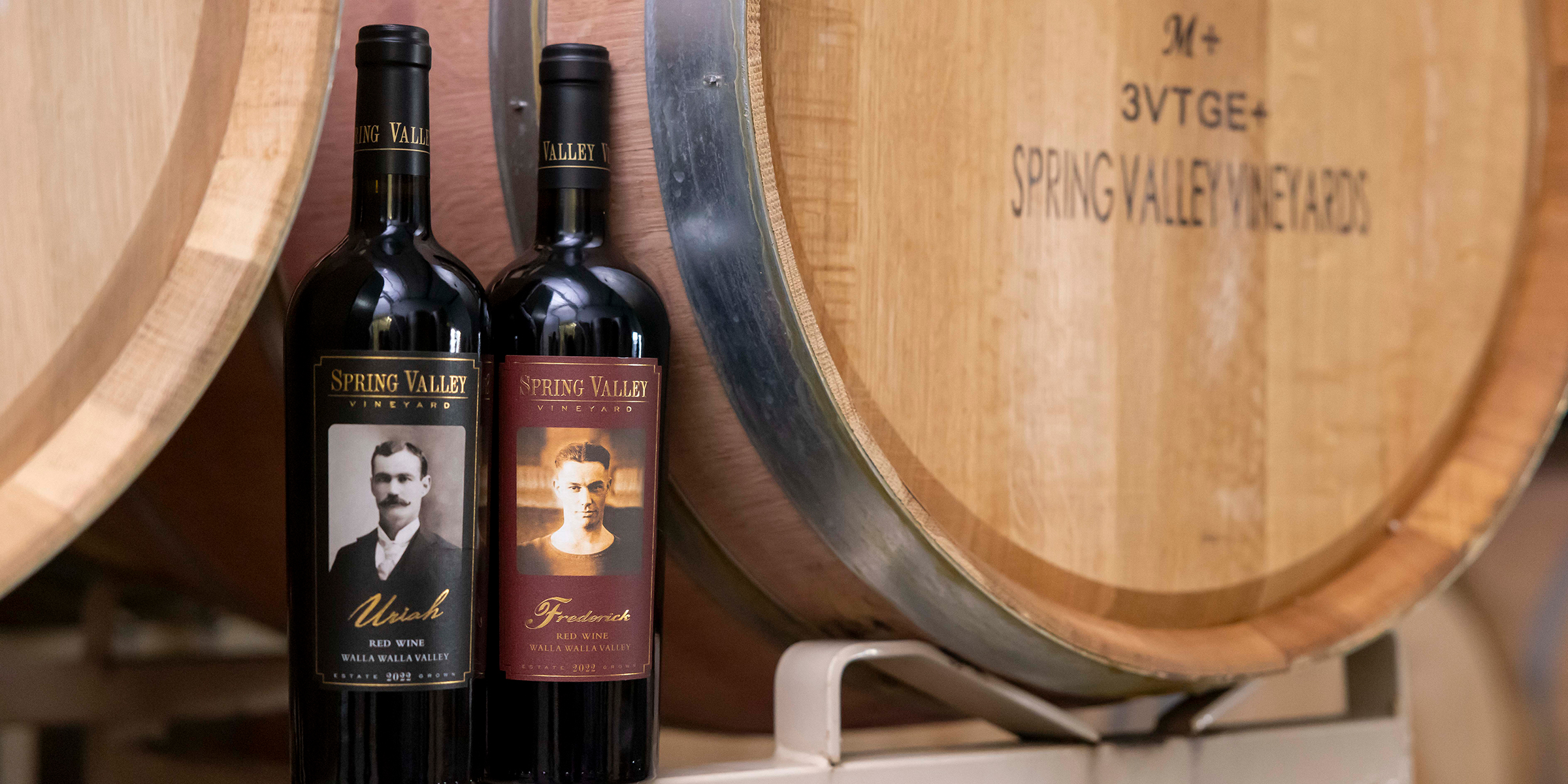 Wine bottles in front of a wine barrel 