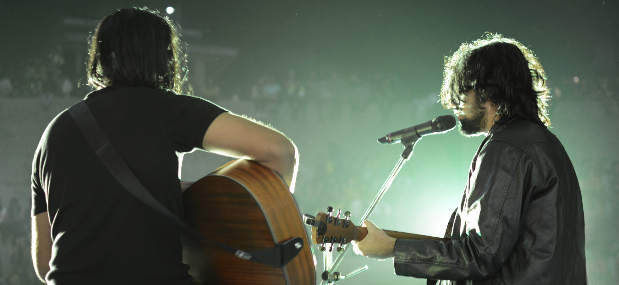 musicians playing guitars on a stage