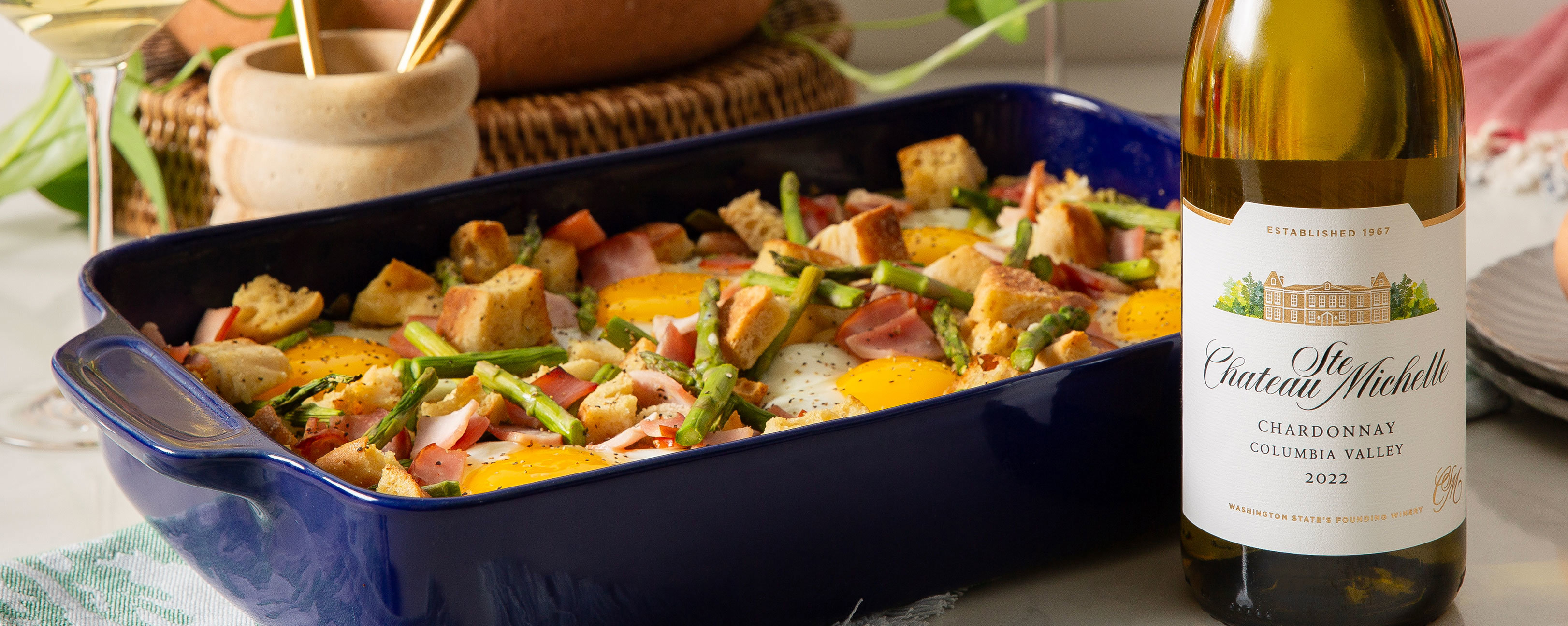 Eggs benedict strata with a bottle of Chardonnay