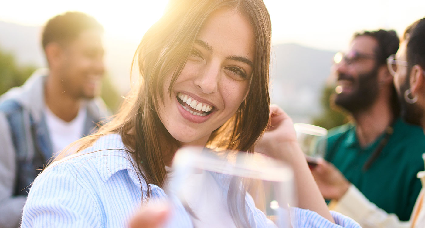 Woman holding up a glass of wine and smiling
