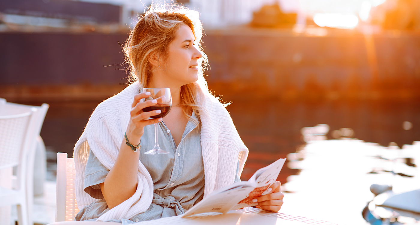 Woman holding up a glass of wine and smiling