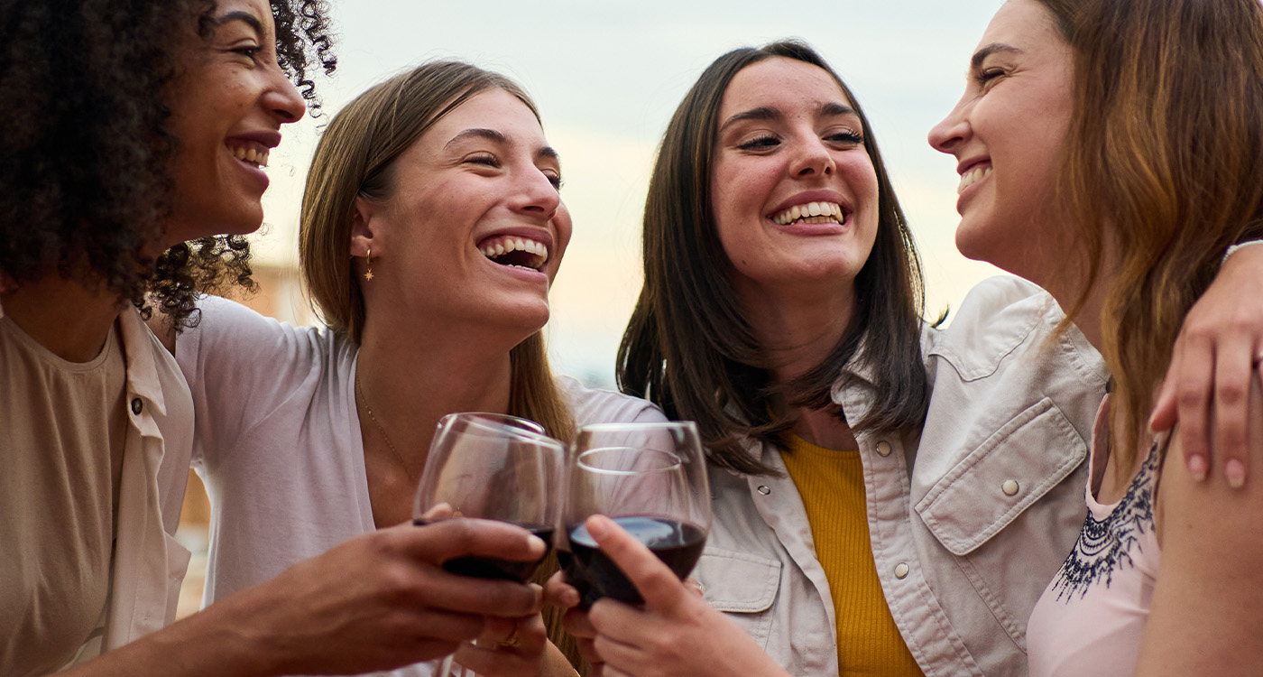Woman holding up a glass of wine and smiling
