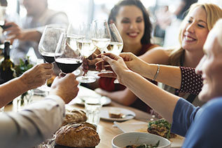 Women sitting at a table and toasting with wine
