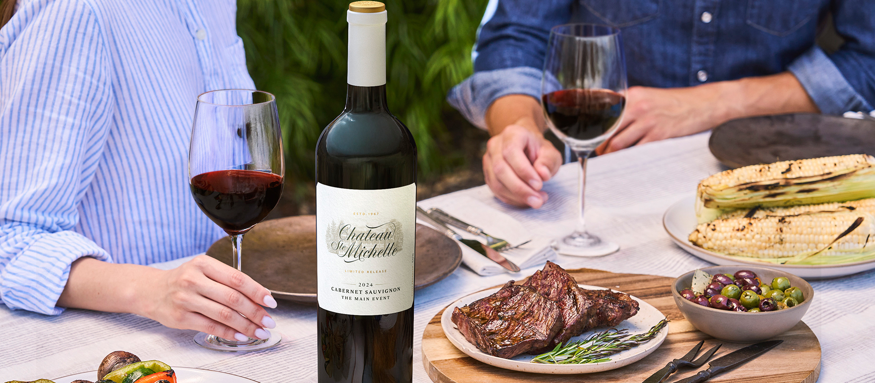 People enjoying food and a glass of red wine