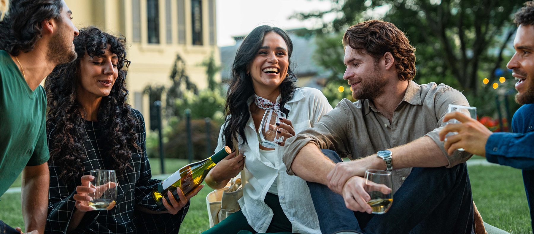 People enjoying wine on the grass in front of the Chateau