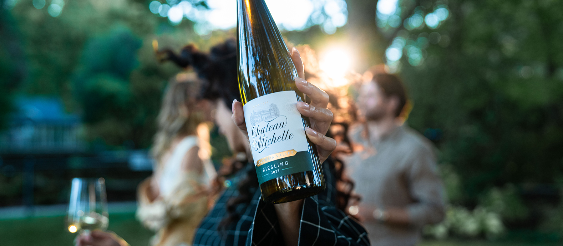 The person holding a bottle of Chateau Ste. Michelle Riesling