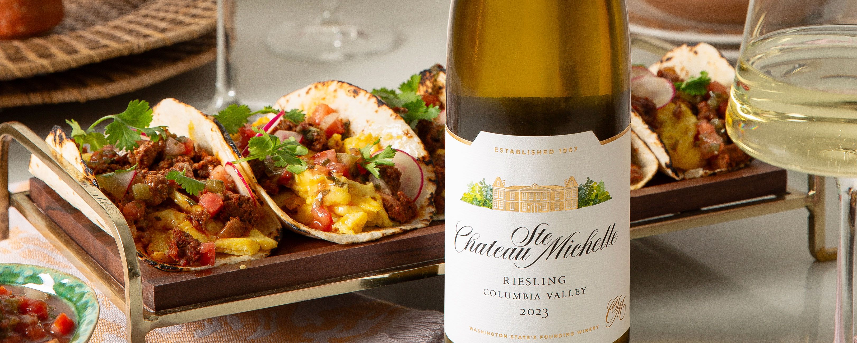Platter of breakfast tacos with a bottle of Riesling