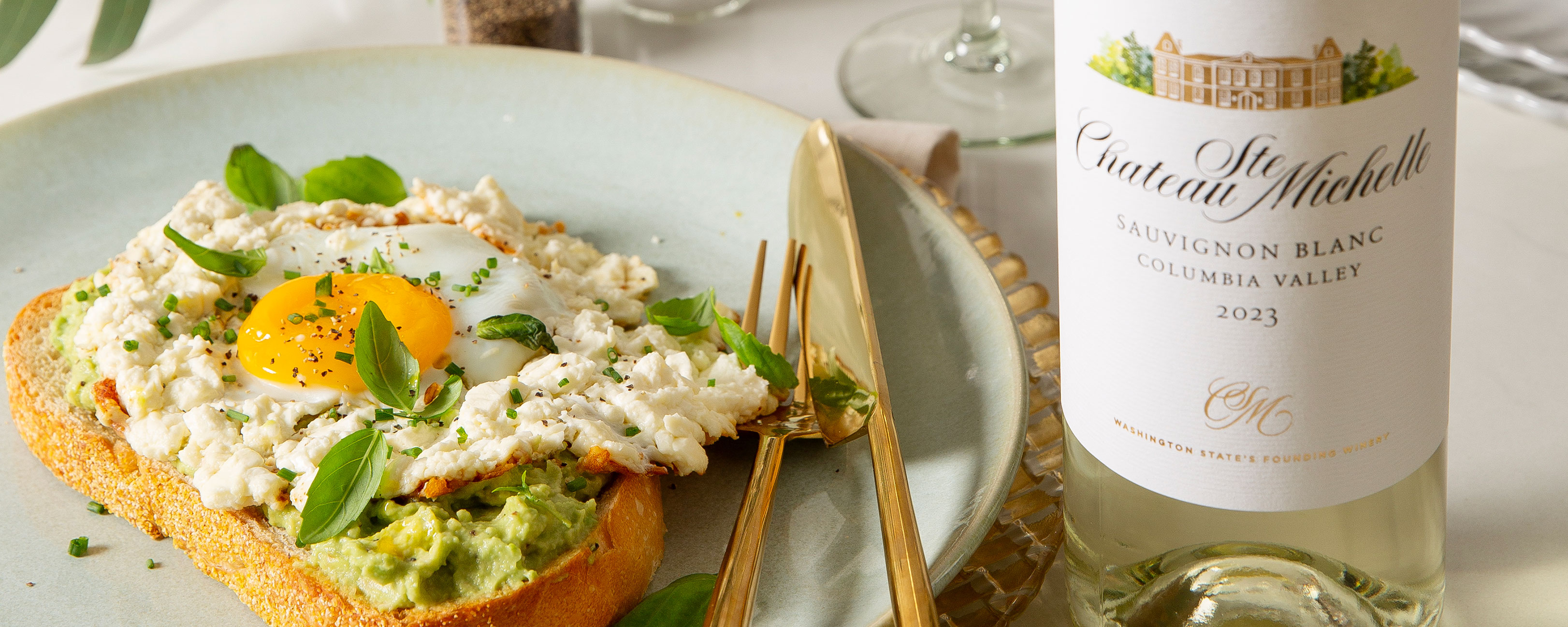 Toast with avocado and egg and a bottle of Sauvignon Blanc