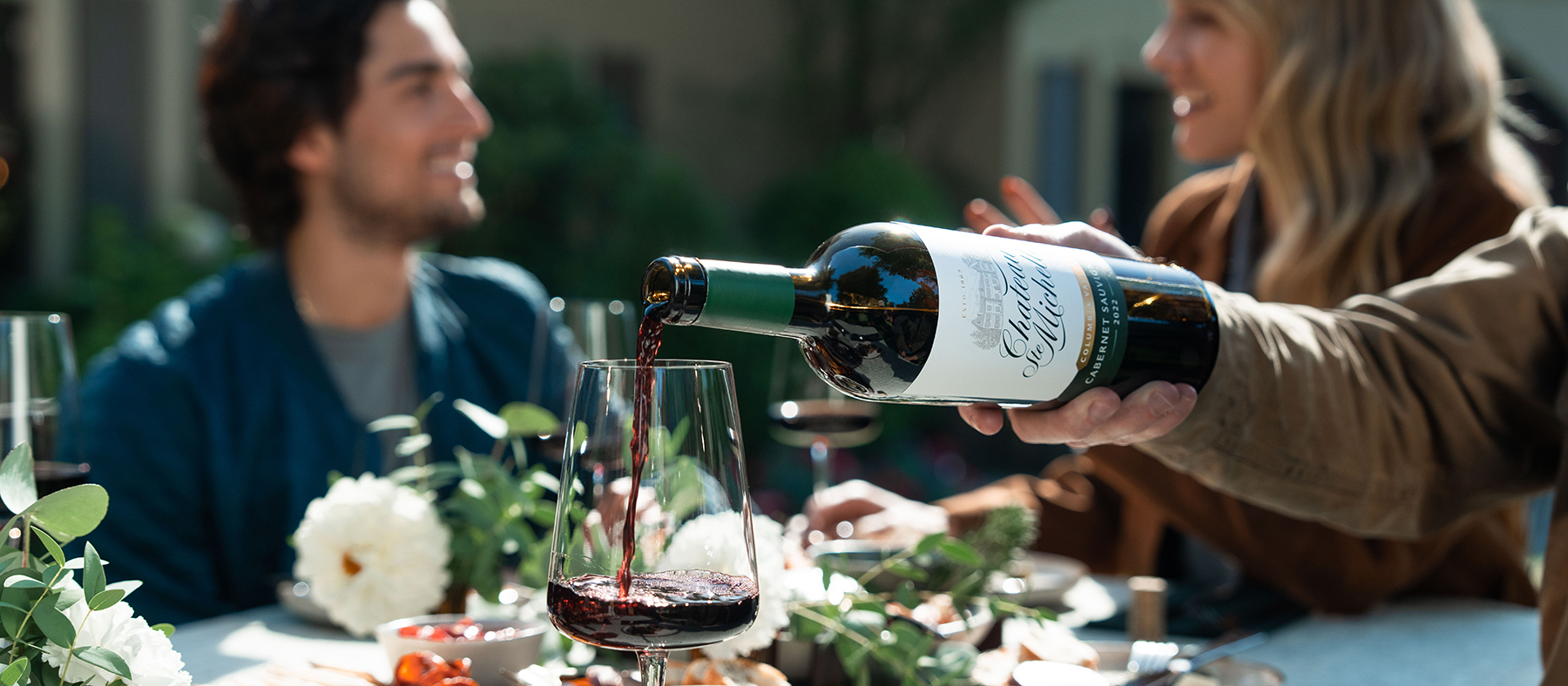 pouring red wine into a glass on on table