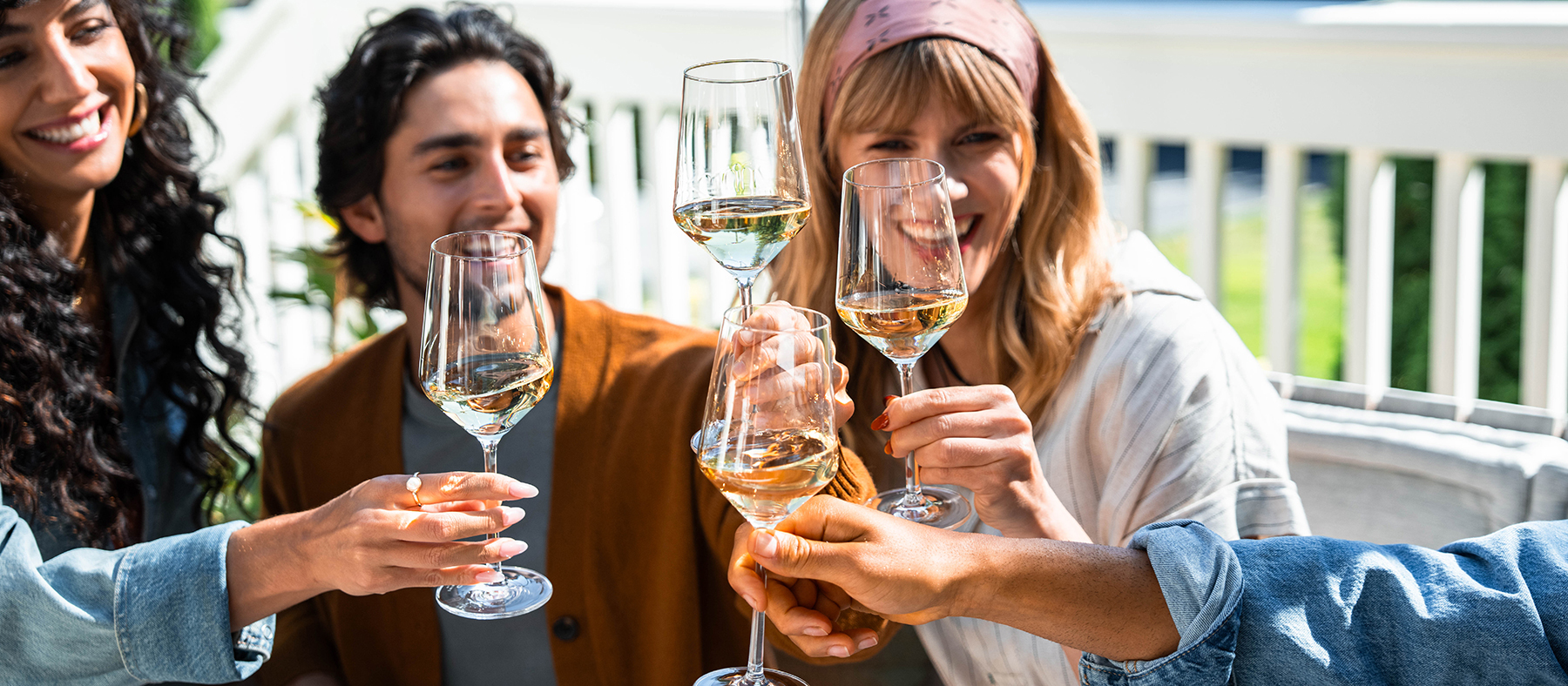 People, smiling and cheering with white wine