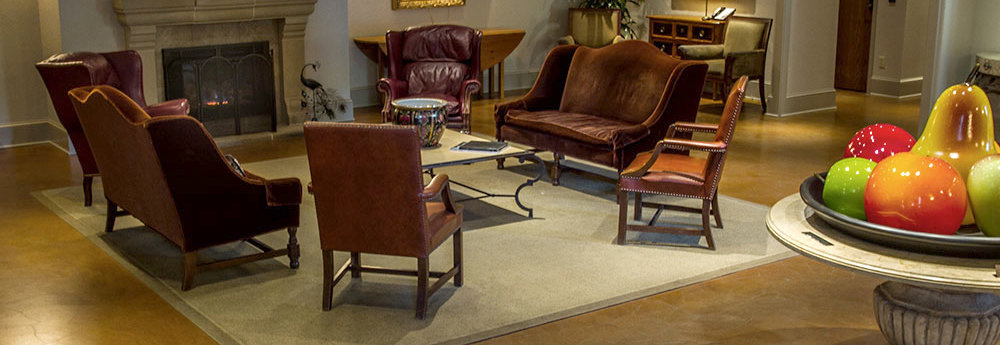 Chairs around the table on a carpet in front of a fireplace