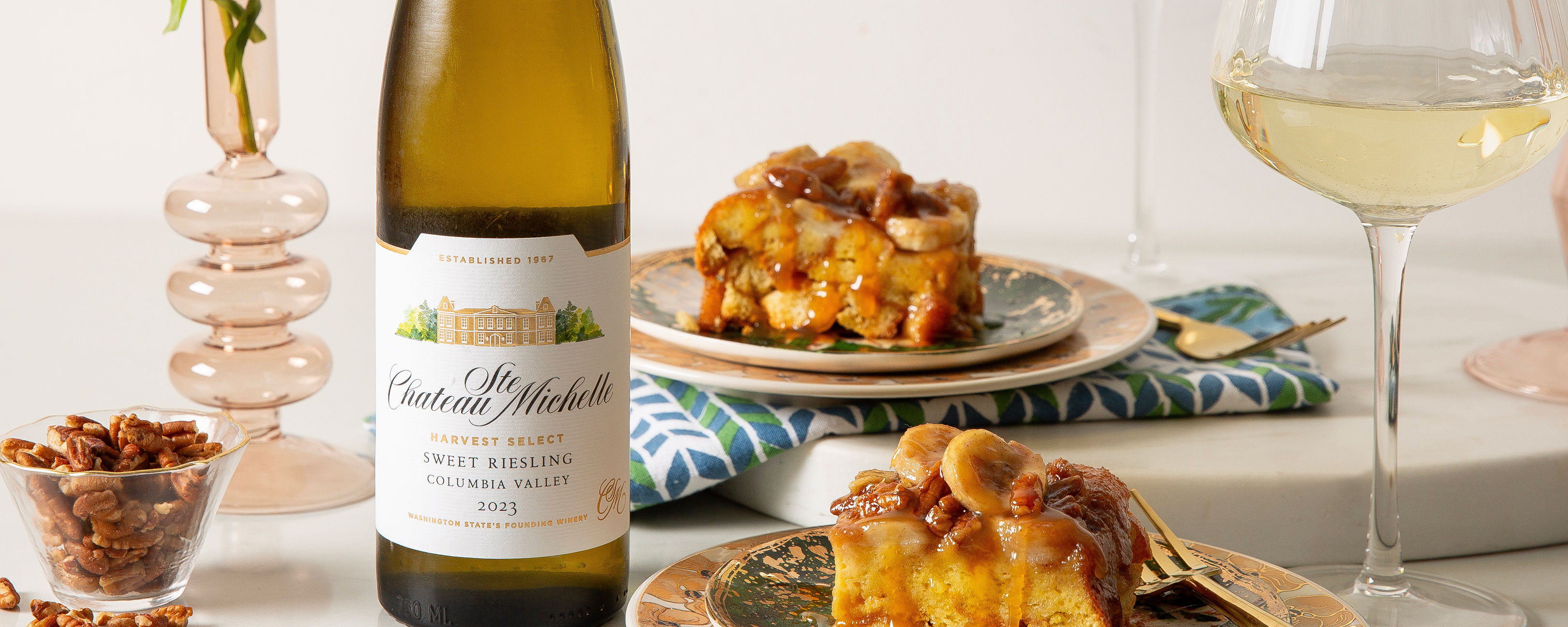 Bananas foster on plates with a bottle of Sweet Riesling