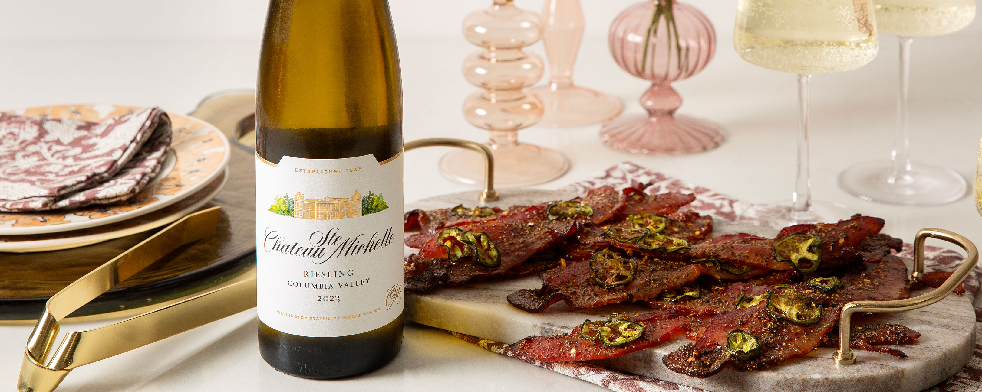 Hot Honey Bacon on a platter with a bottle of Riesling
