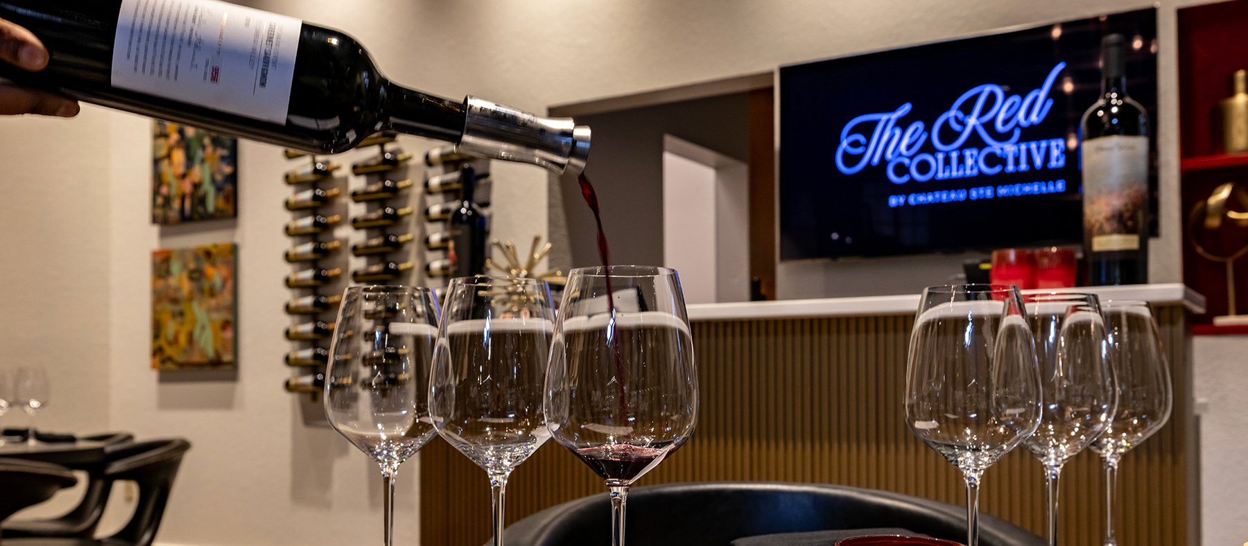 Red wine bean poured into a glass near a tasting bar