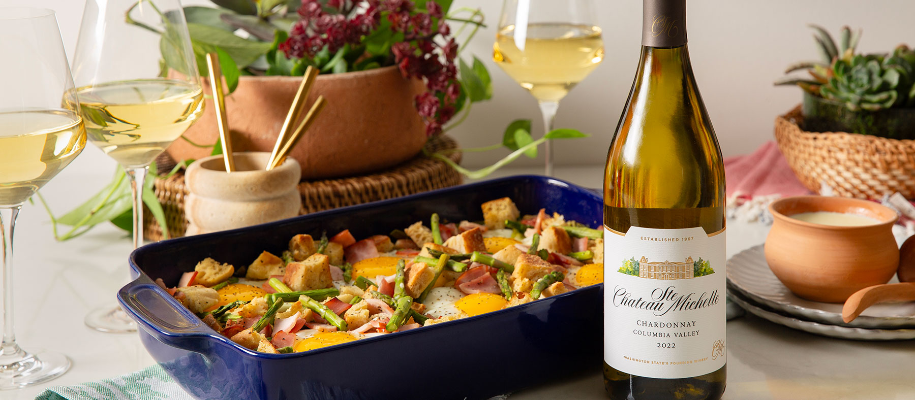 Eggs benedict strata with a bottle of Chardonnay