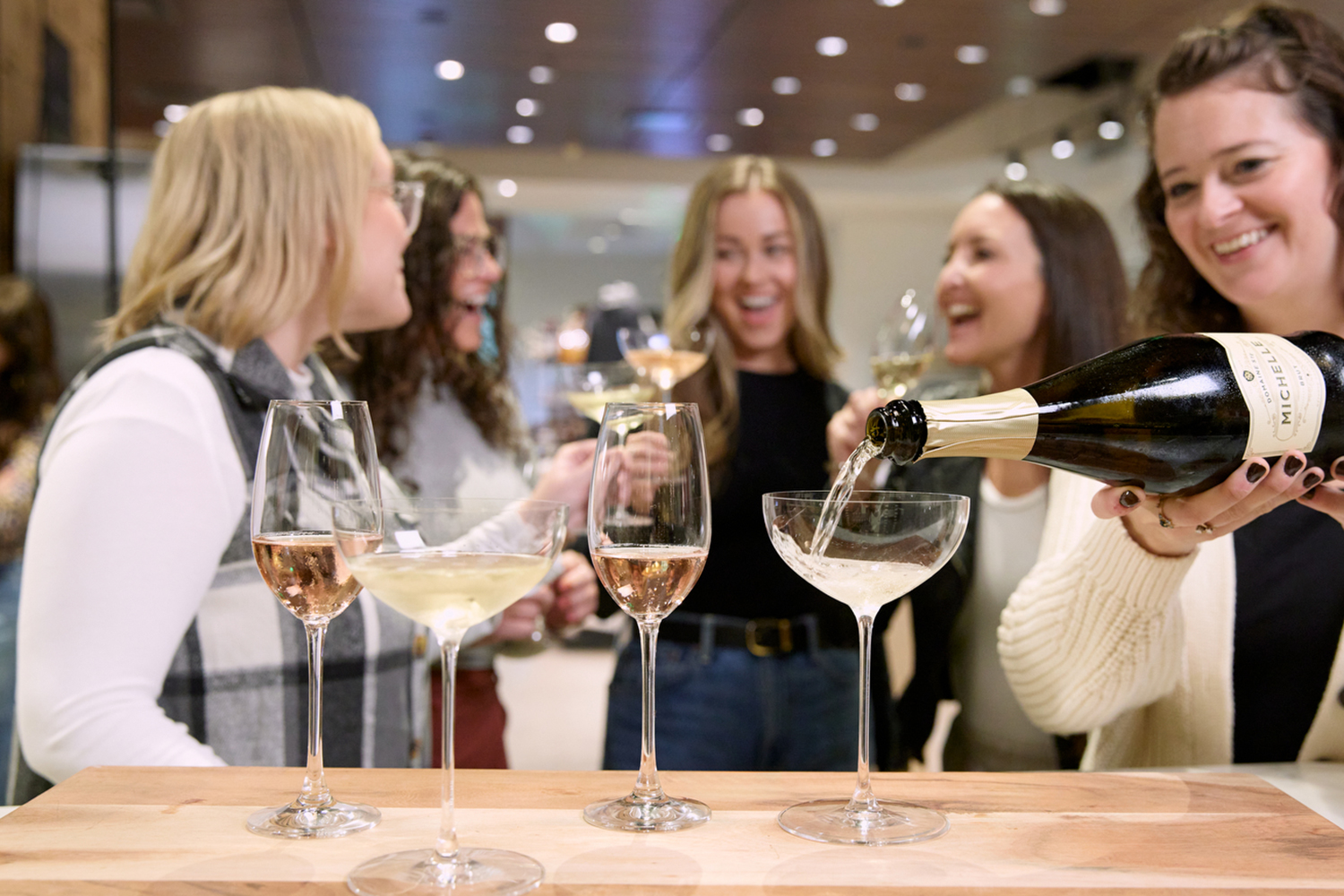 people laughing and pouring sparkling wine
