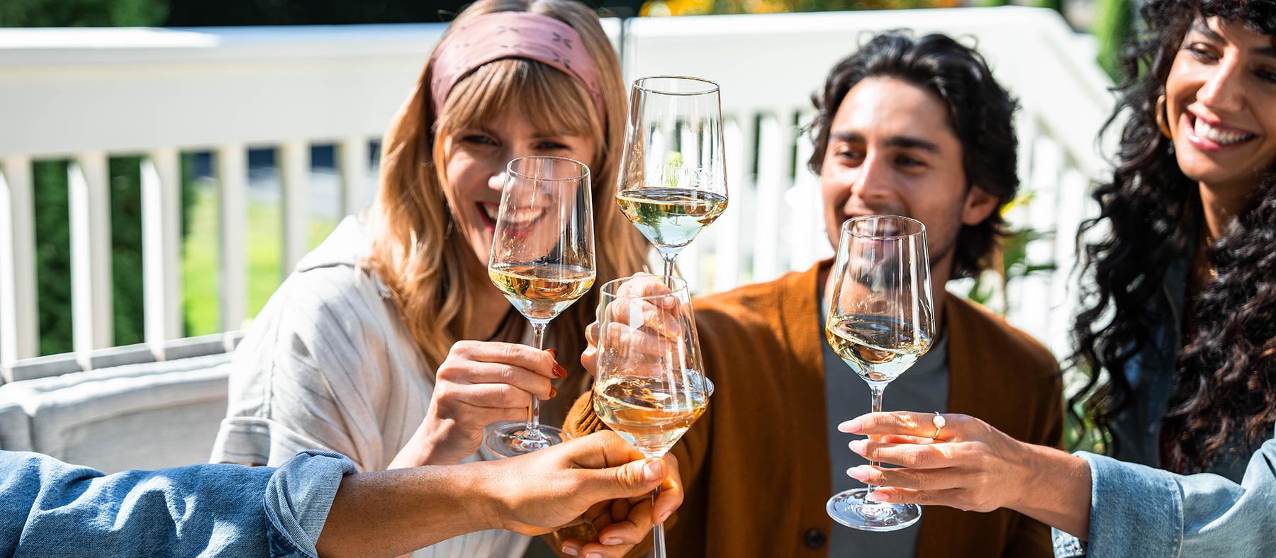 People cheering with glasses of white wine