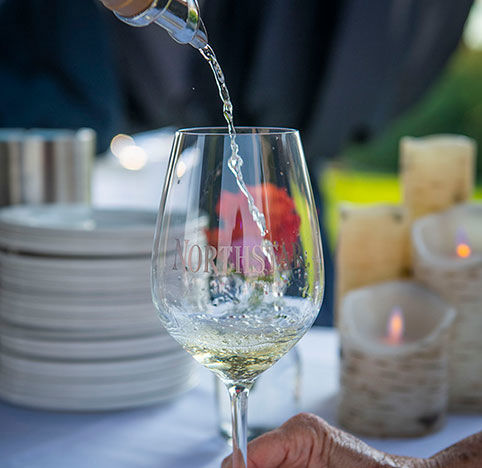 A glass of white wine being poured at an event