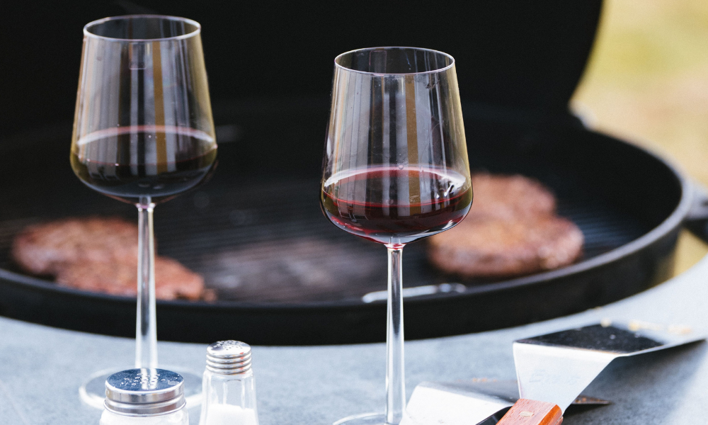 Glasses of red wine by a grill