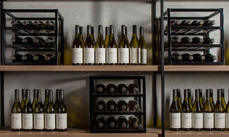 Organized sets of Chateau Ste Michelle white wines upright and on wine racks