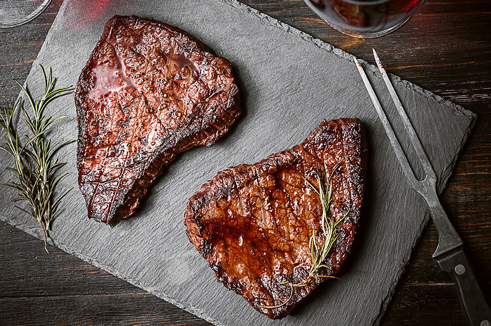 Steaks on a slate board with a glass of red wine