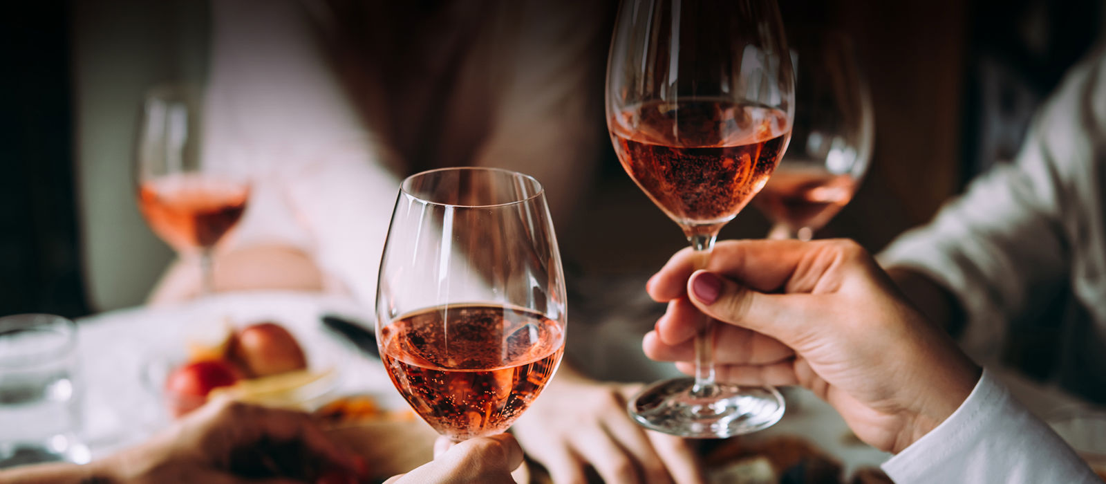 Glasses of rosé held in preparation for a toast 