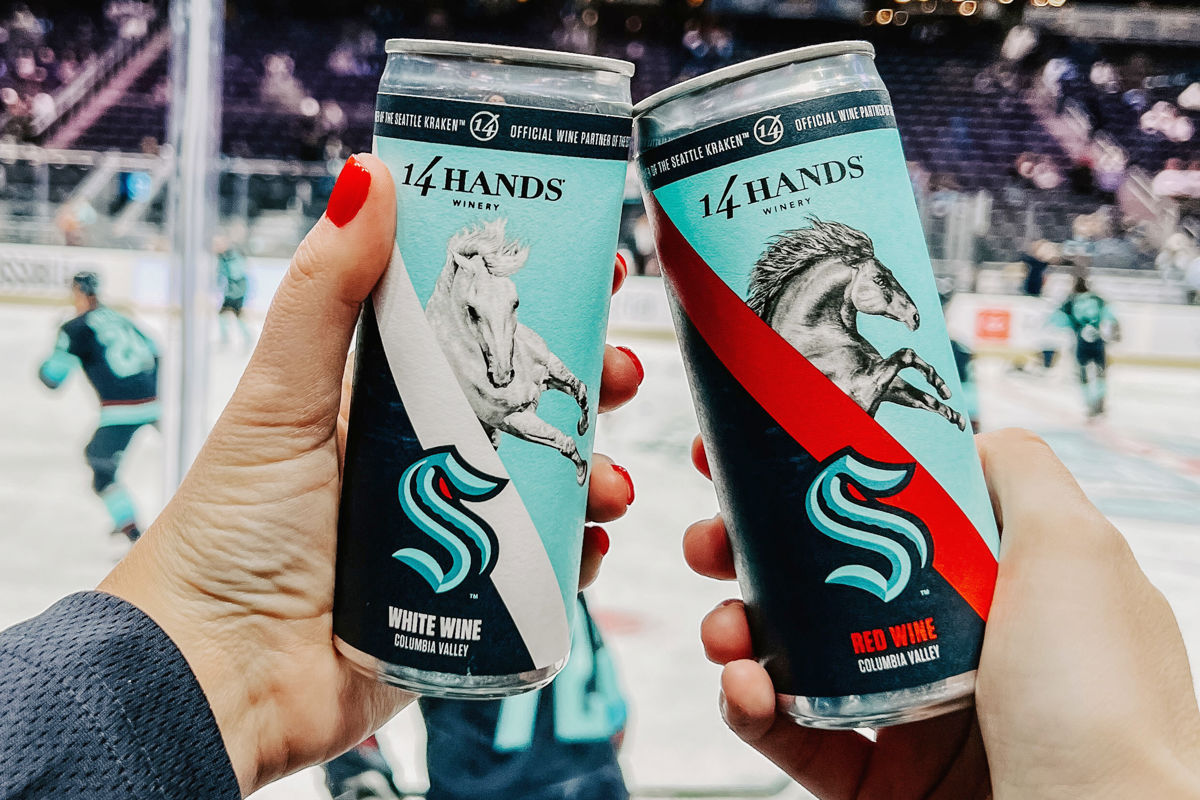 A toast with Kraken Cans at a hockey game