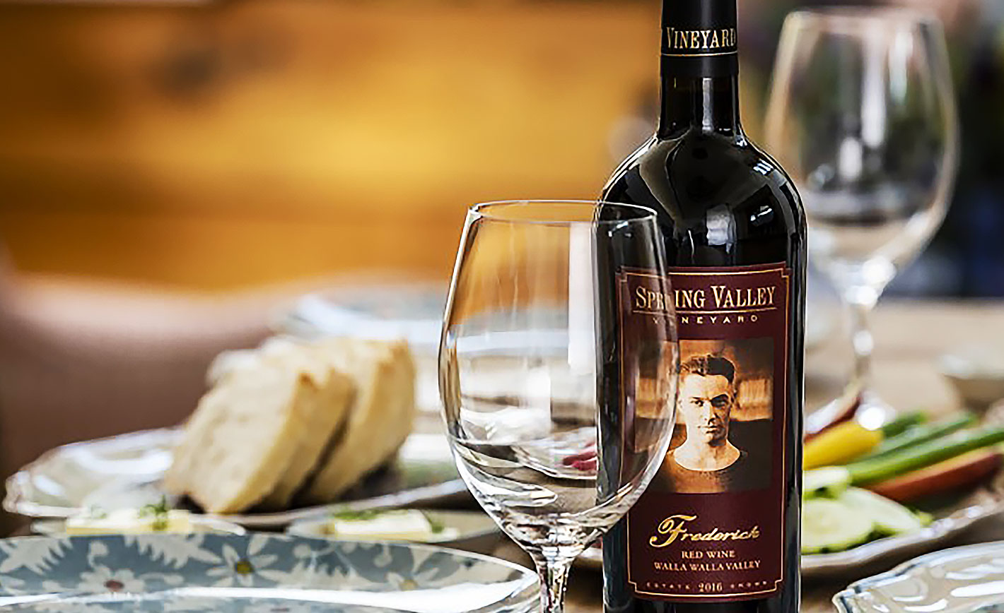 A bottle of Frederick red blend next to a wine glass