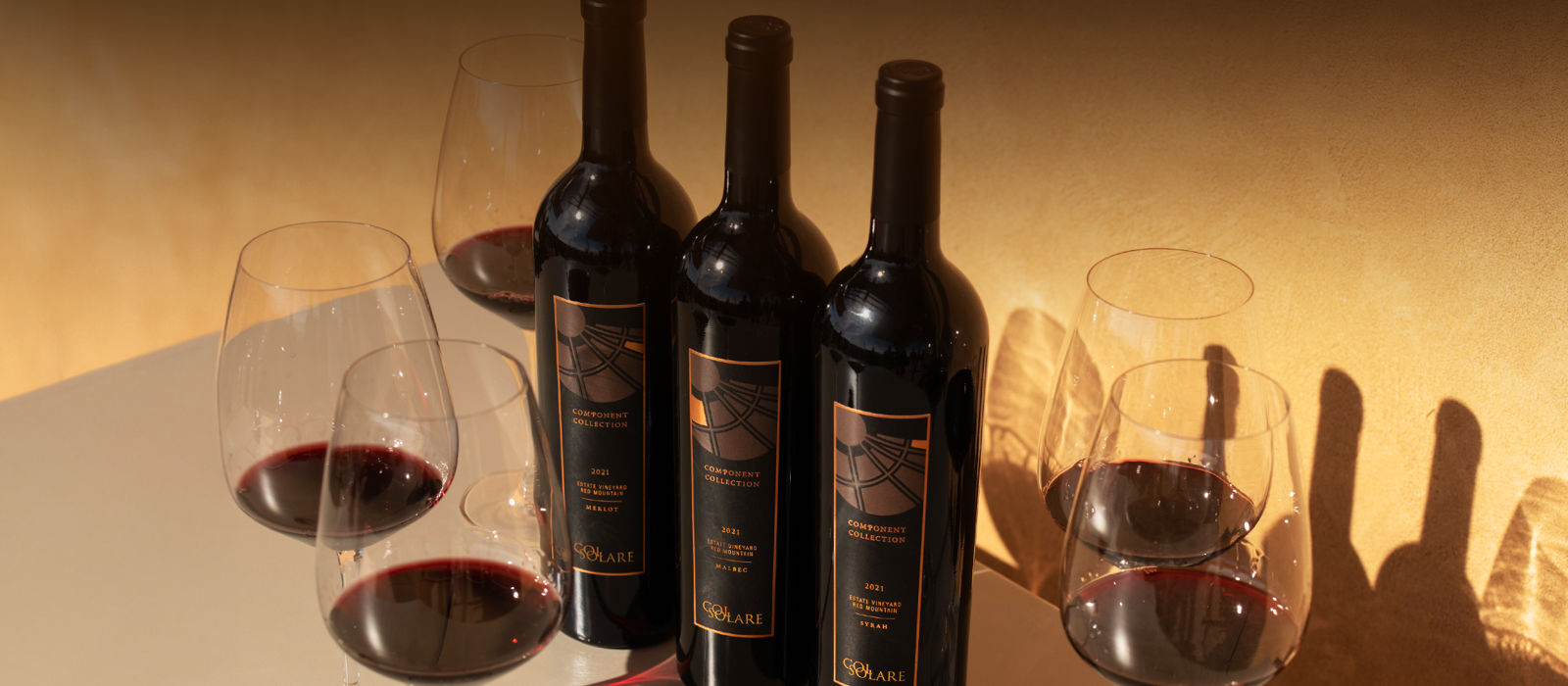Bottles of Col Solare wine with glasses of red wine