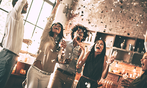 A a diverse group of 5 people drinking wine under a sprinkle of confetti