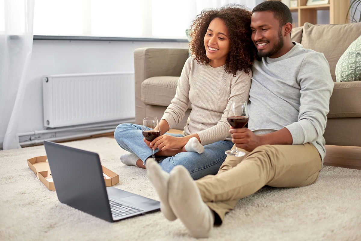 A couple with wine and a computer