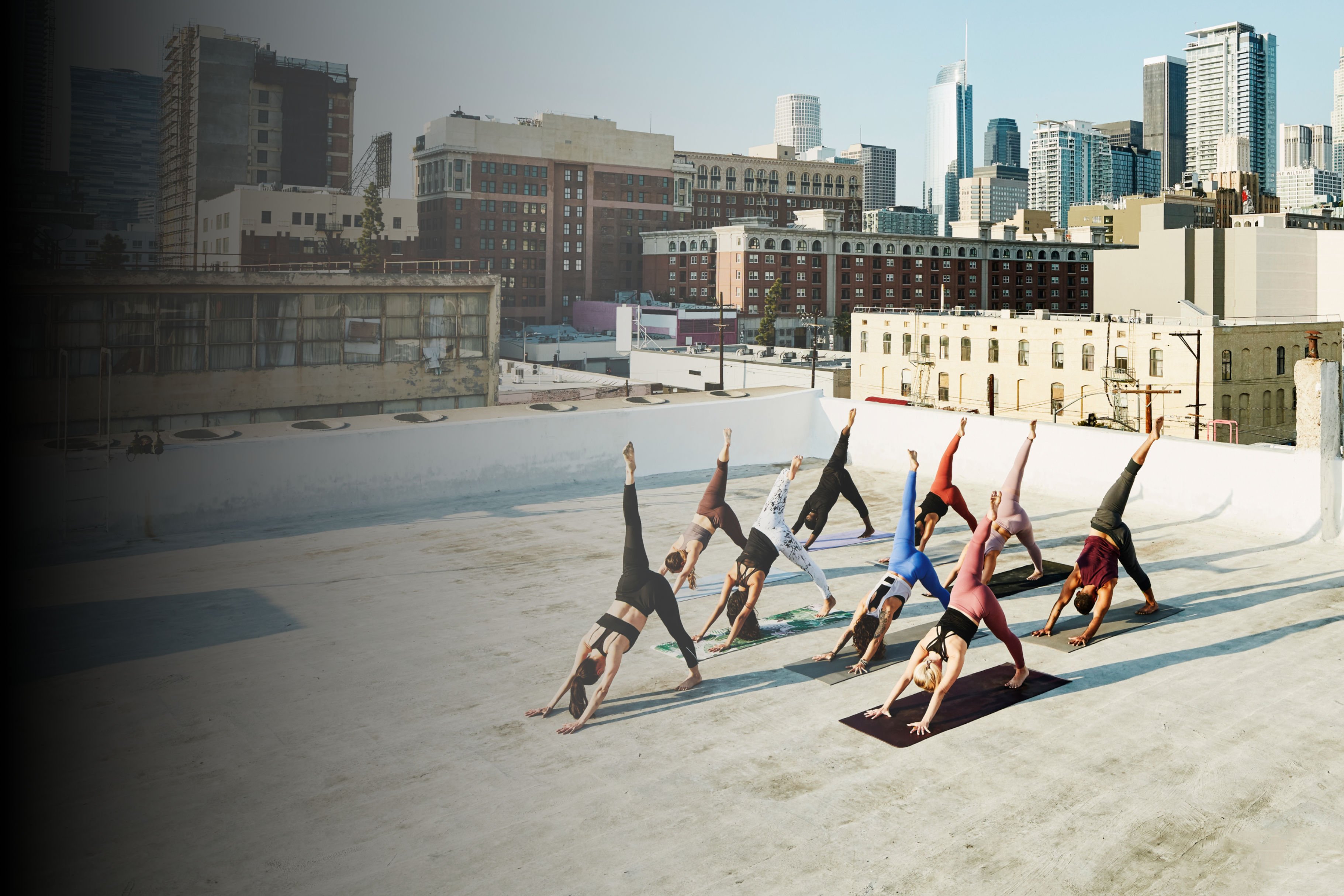 Yoga instructor leads a group session on a city rooftop