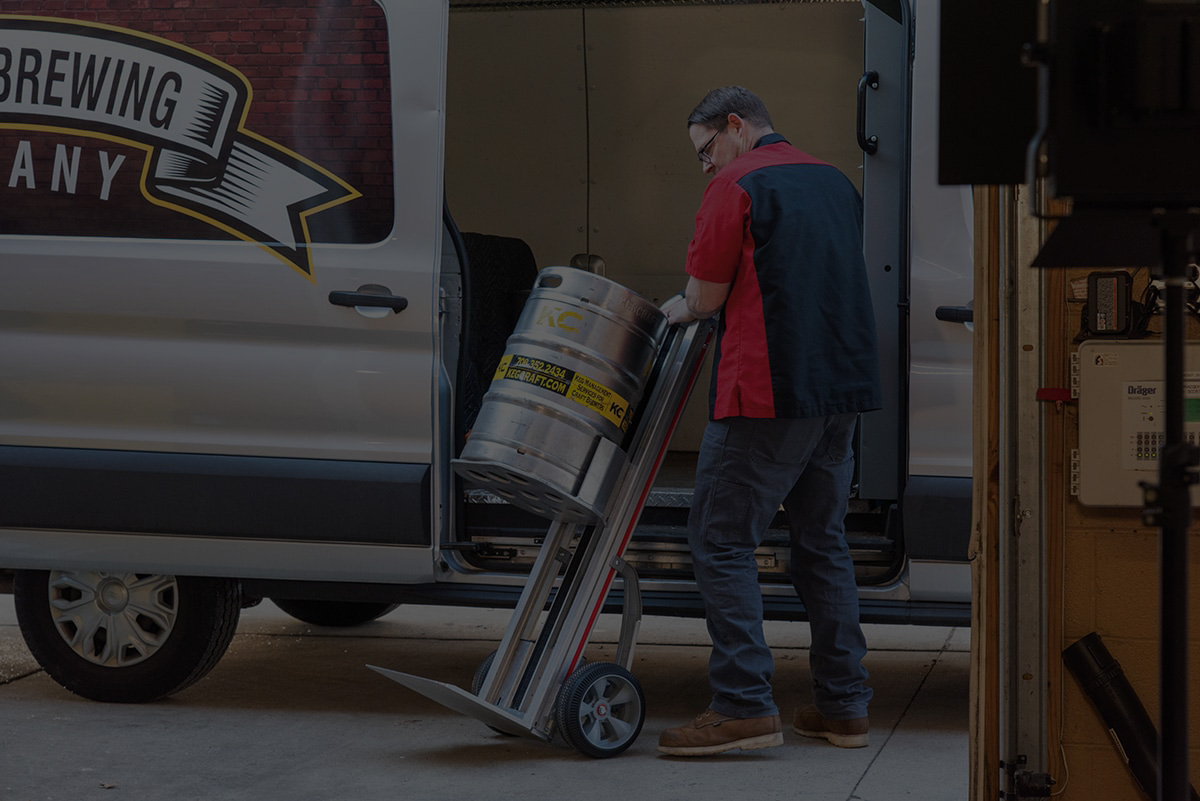 Man holiding a Magliner hand truck carrying a keg