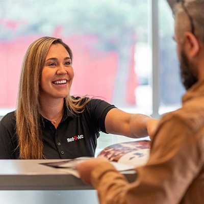 Sales associate showing customer a brochure over the counter
