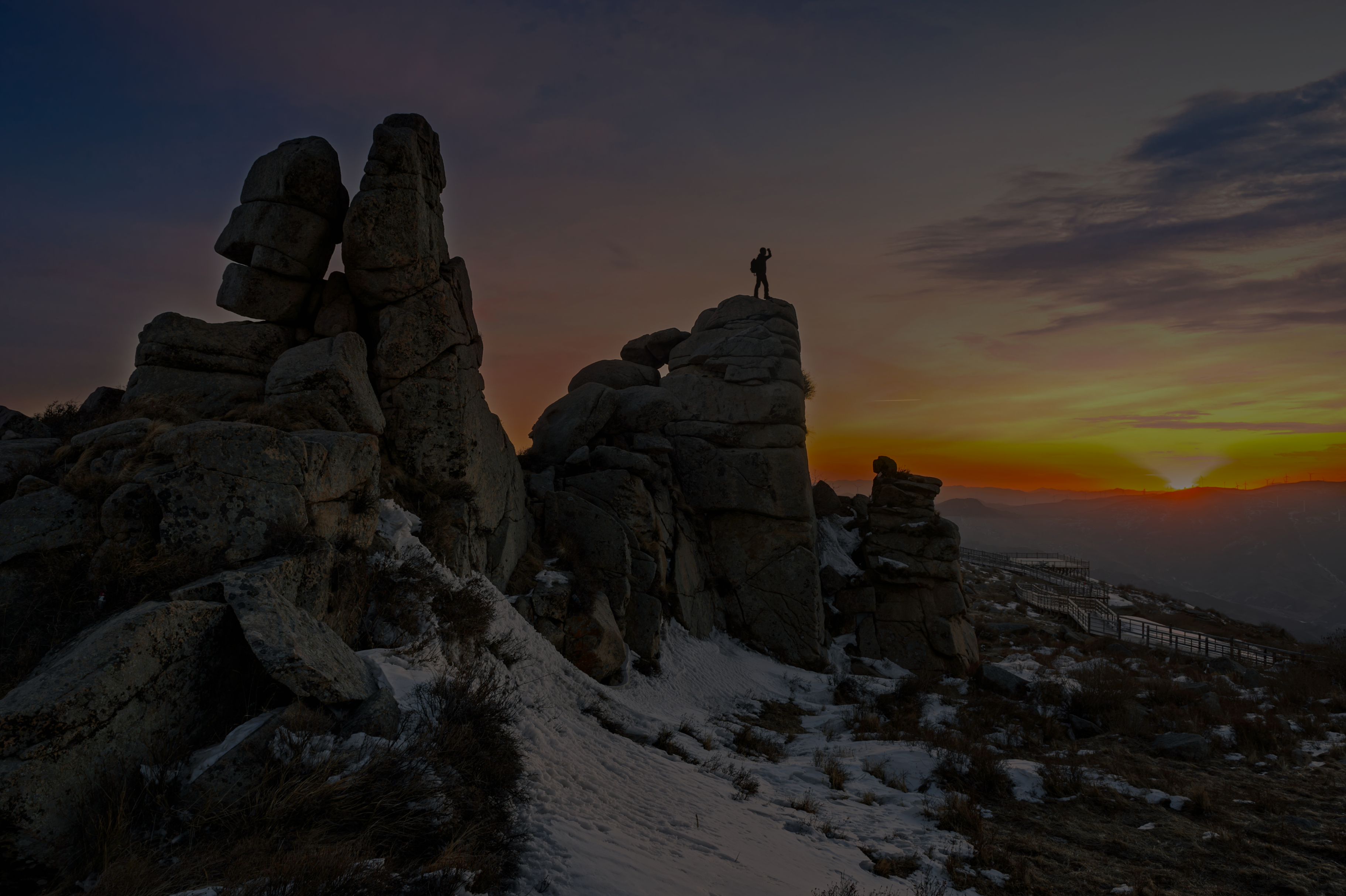 Hiker looking over landscape at sunset