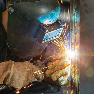 Soudeur MIG soudant des matériaux industriels