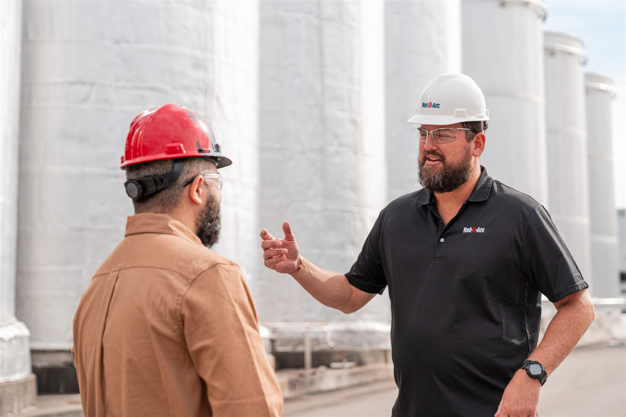 Employé engageant une conversation avec un client sur le site d'une usine de fabrication