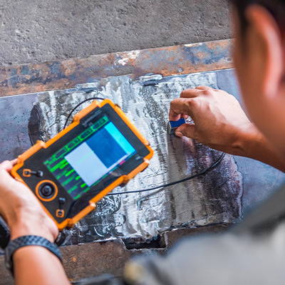 Man performing non-destructive testing on industrial material