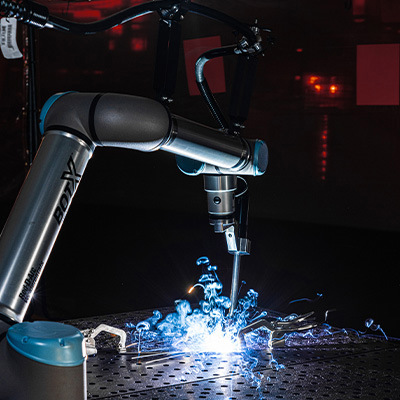 Le système de soudage BotX cobot effectue une soudure dans un atelier sombre